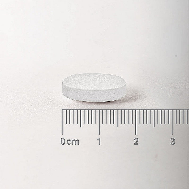 White pill with a ruler for scale on a white background