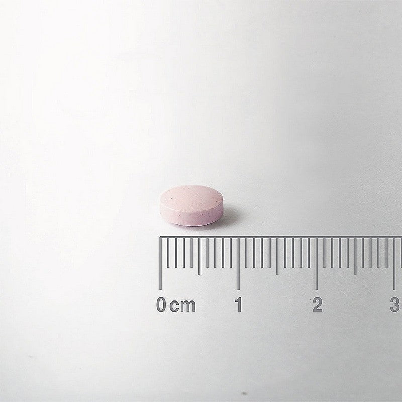 Pink pill on a white background with a ruler for scale.