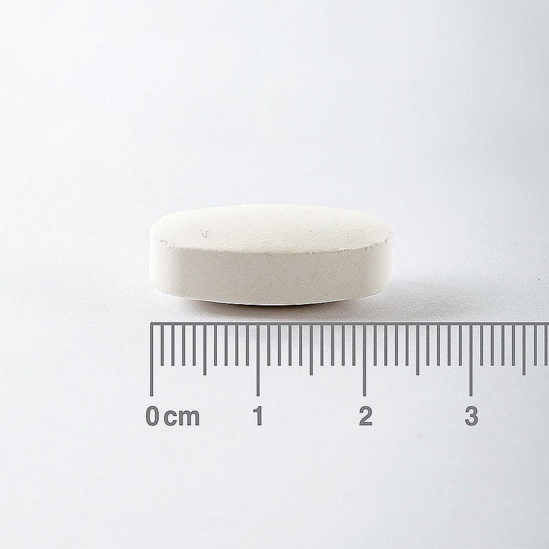White pill with a ruler for scale on a white background